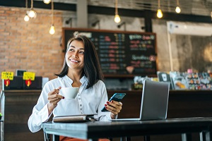 woman-sitting-happily-working-with-smartphone-coffee-shop-notebook-1024x681-2.jpg